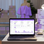 Notebook aberto exibindo o dashboard de vendas da Appmax, o melhor gateway para Shopify, em um ambiente de e-commerce com pacotes de entrega e manequim